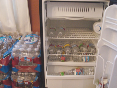 The mini-fridge in our dining room is stocked with bottles from the 32-packs shown on the left.